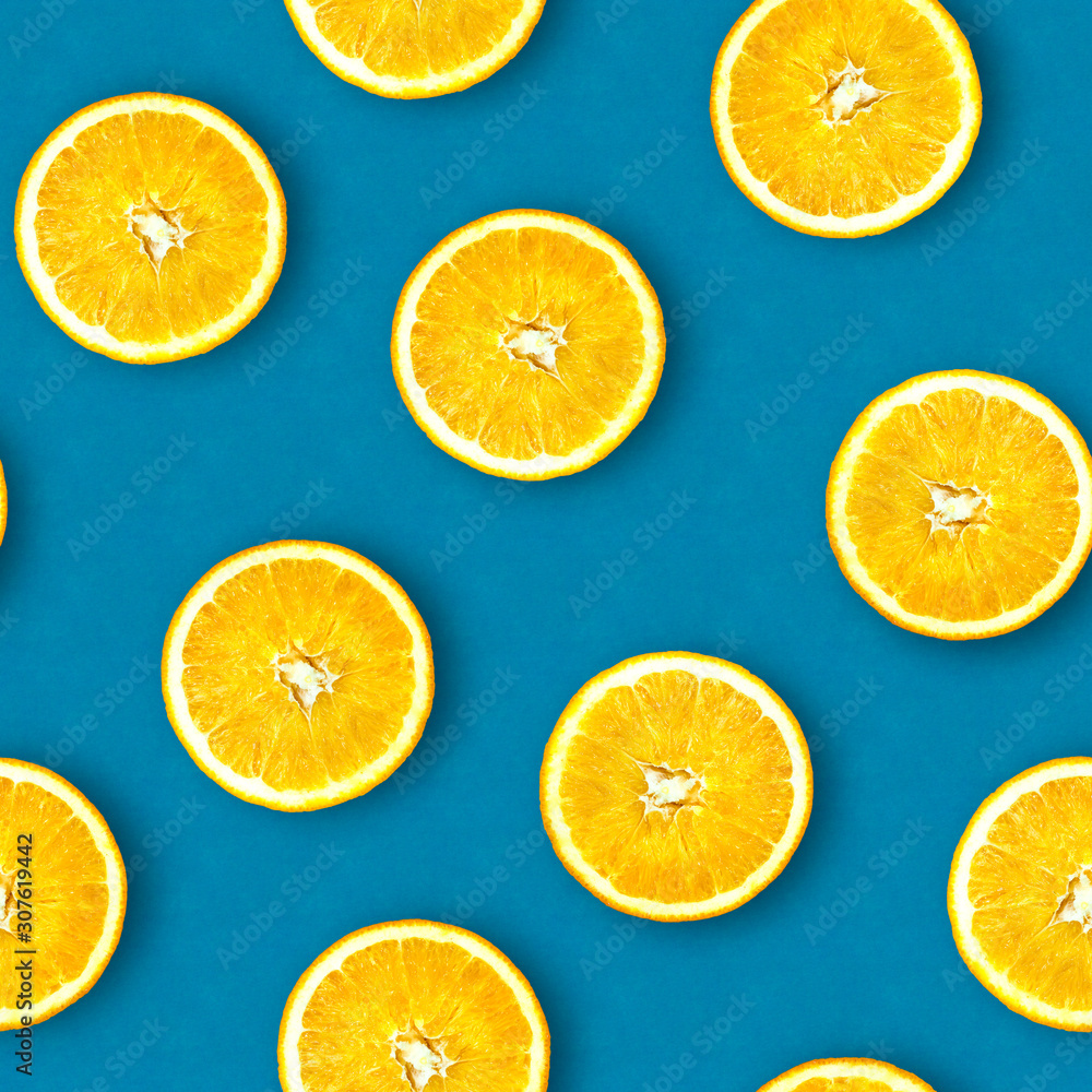 Seamless pattern of oranges. Bright blue background. Juicy orange in a cut. Citrus fruit.