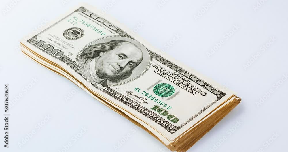 Growing up and down bundle of 100 dollars bills on the white background, tight framing, timelapse Growing up and down bundle of 100 dollars bills on the white background, tight framing, timelapse