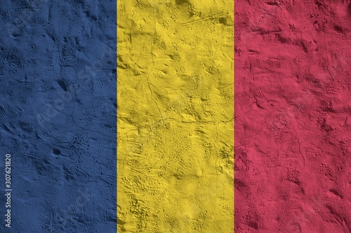 Chad flag depicted in bright paint colors on old relief plastering wall. Textured banner on rough background photo