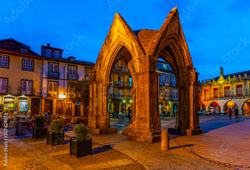 Sunset view of people strolling over Largo da Oliveria in the old town of Guimaraes, Portugal photo