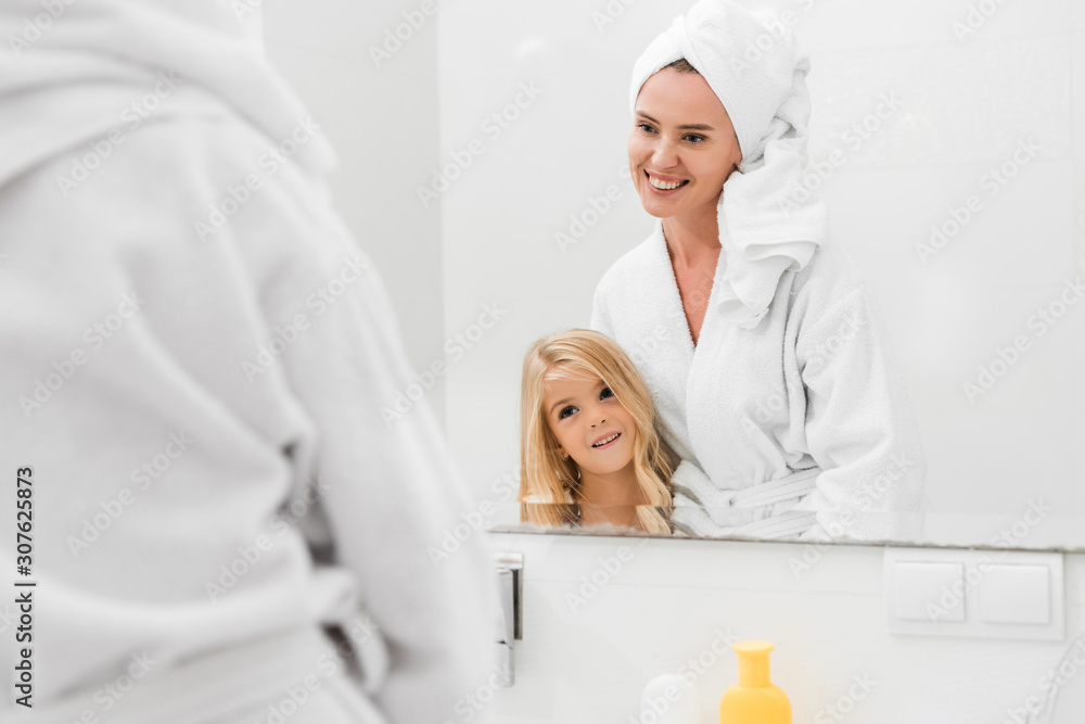 selective focus of happy mother and cute daughter looking at mirror in bathroom selective focus of happy mother and cute daughter looking at mirror in bathroom