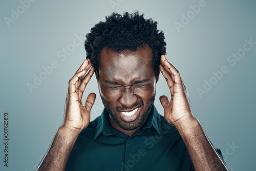 Papier peint Frustrated young African man making a face while standing against grey backgroun