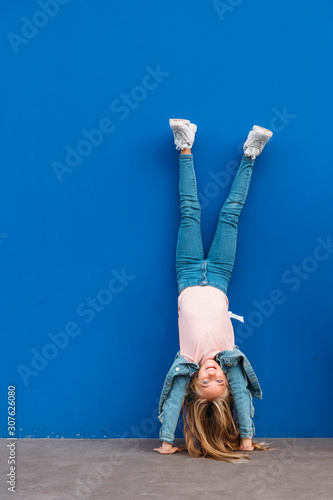 Fotografie, Obraz Little girl kid handstanding at the same time in the street.