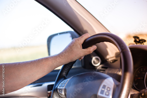 a man drives a car and turns the steering wheel