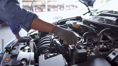 Mechanic man examining and maintenance to customer the engine a vehicle car hood, Safety inspection test engine, transportation repair service center,  4K UHD cinematic footage