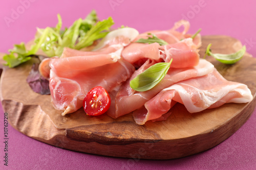 prosciutto ham and basil on wooden board