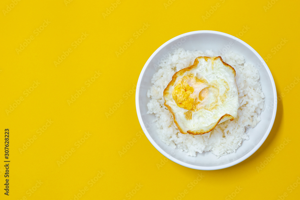 cooked rice with fried egg on bowl on yellow background cooked rice with fried egg on bowl on yellow background