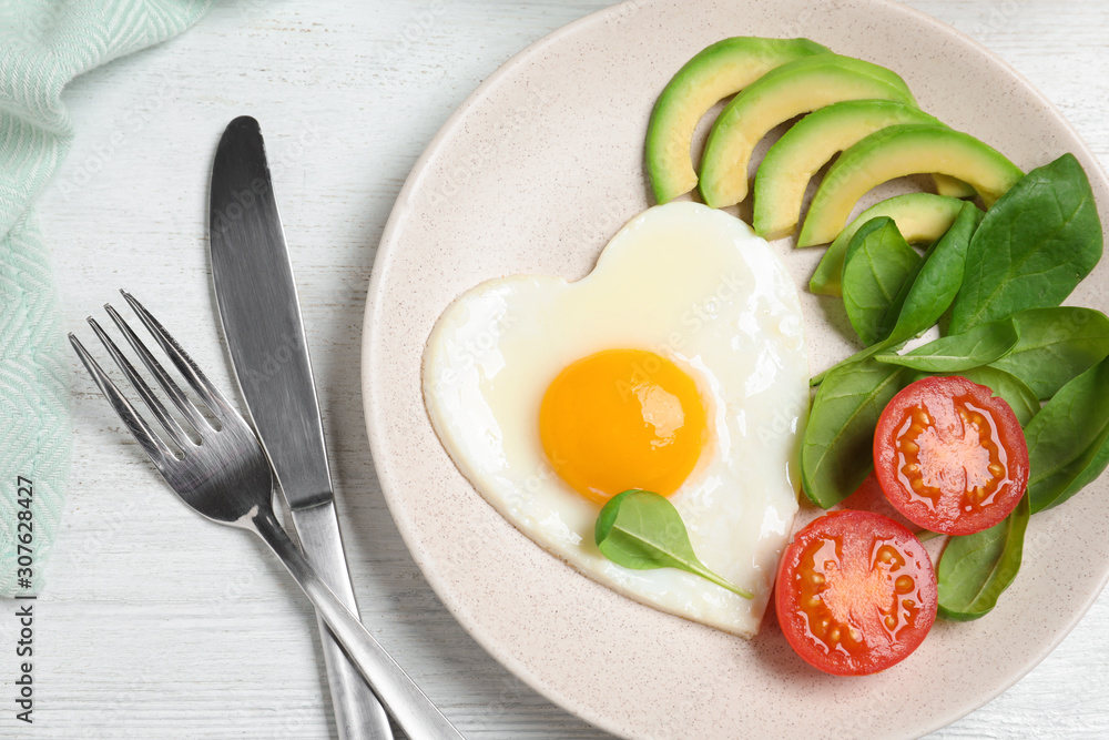 Tasty breakfast with heart shaped fried egg served on white wooden table, flat lay Tasty breakfast with heart shaped fried egg served on white wooden table, flat lay