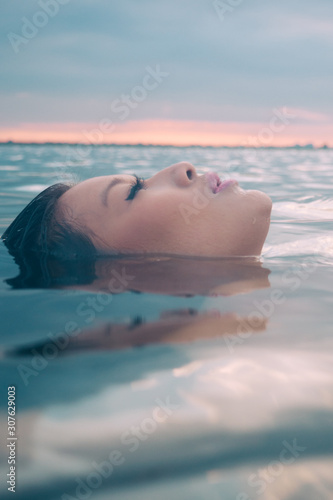 Asian model in the water enjoying a wellness spa.