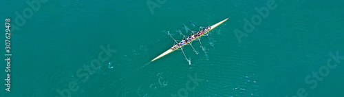 Aerial drone top panoramic view of sport canoe rowing synchronous athletes competing in tropical exotic lake