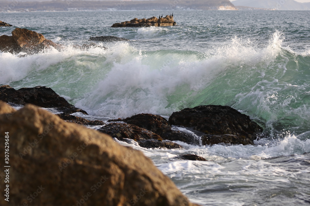 Ocean waves hitting the rocky sea beach.