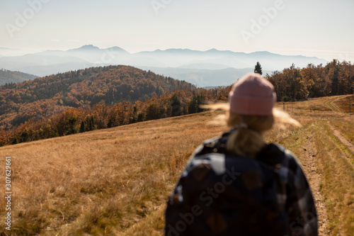 Obraz na płótnie Hiker woman with backpack walking in the mountains in autumn scenery. w salonie