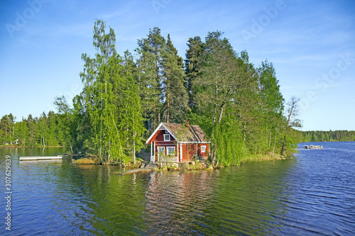 Fotografija Island on lake in Finland with red summer cottage
