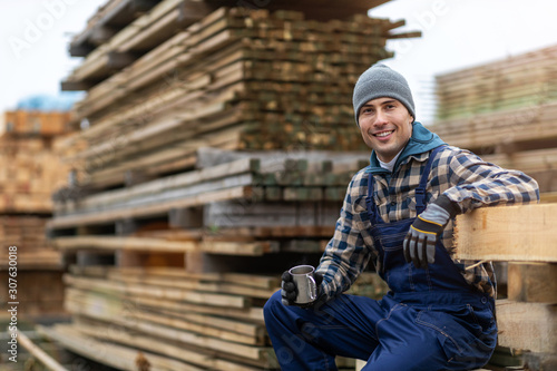 Young male worker in timber warehouse 