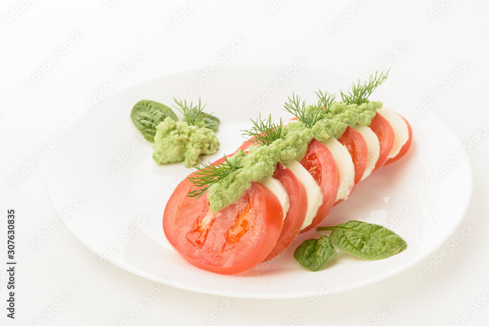 Caprese salad with tomatoes, mozzarella, spinach and pesto Caprese salad with tomatoes, mozzarella, spinach and pesto