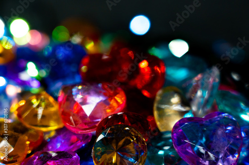 Multi-colored glass pebbles glow in the dark with bright saturated colors. Close-up. Multi-colored faceted glass stones