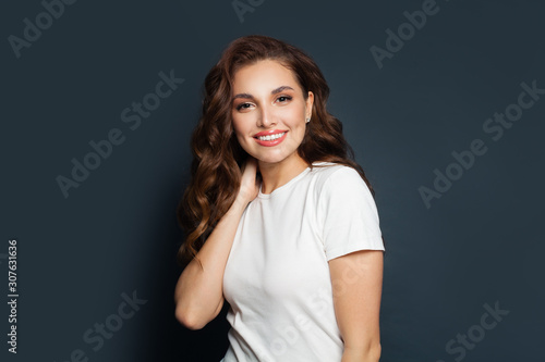 Happy beautiful model woman wearing white t-shirt on gray background