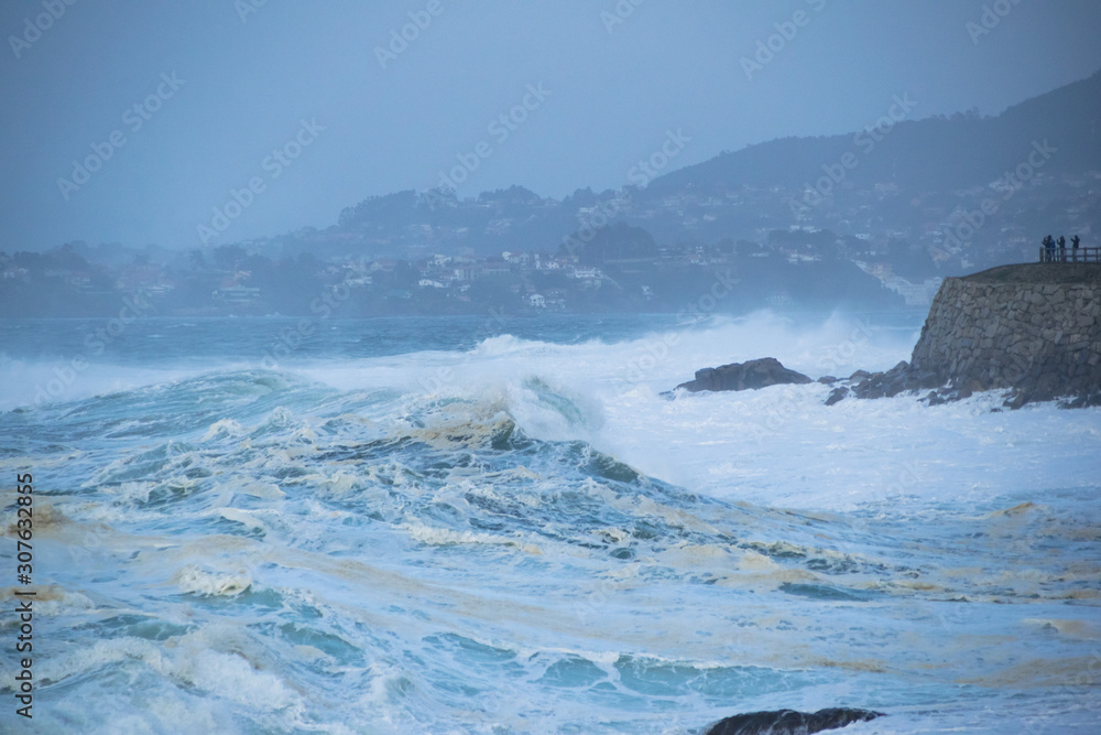 Great waves of the Atlantic Ocean splashing and foaming on the coast of Baiona, Spain. Stormy seascape