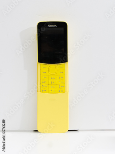 A retro vintage yellow nokia 8110 reloaded mobile phone isolated on a white  background. A re issued modern version of the old nokia classic model.  hipster collectable electronics. Stock-Foto | Adobe Stock