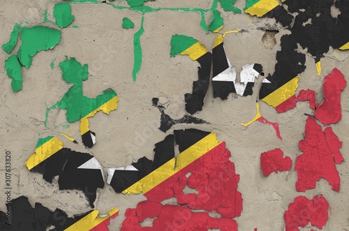 Saint Kitts and Nevis flag depicted in paint colors on old obsolete messy concrete wall closeup. Textured banner on rough background photo