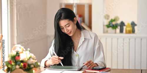 Young female working with her tablet and stylus. photo