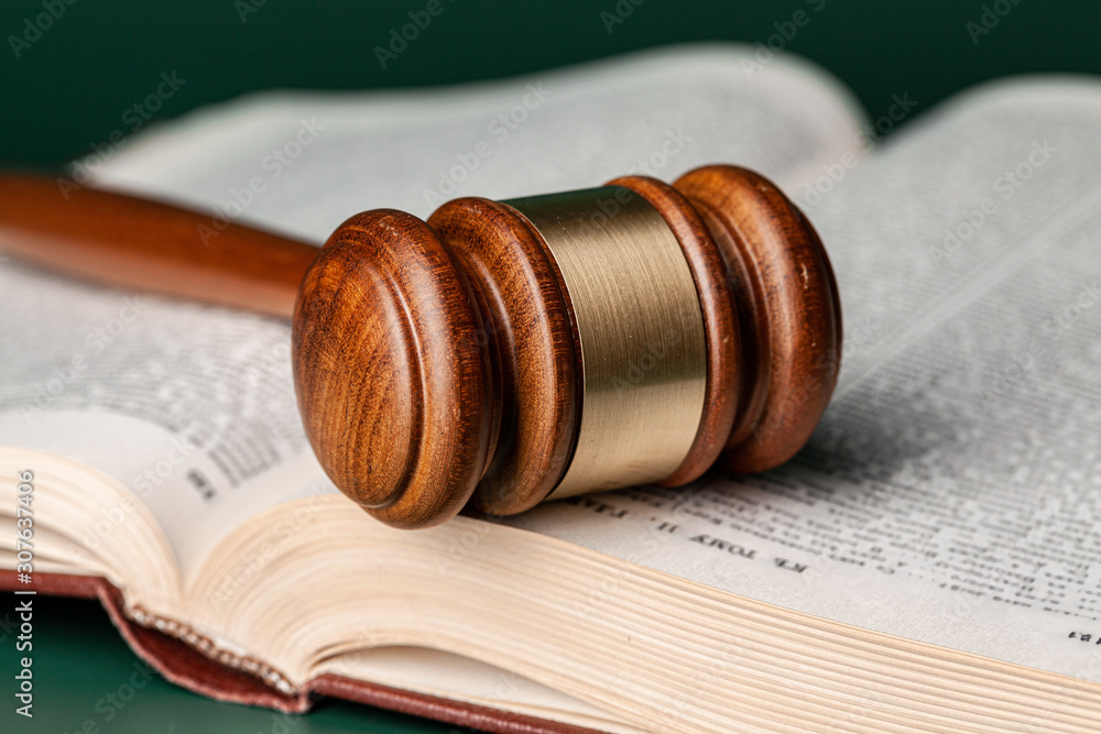 Close up of a brown wooden gavel and book