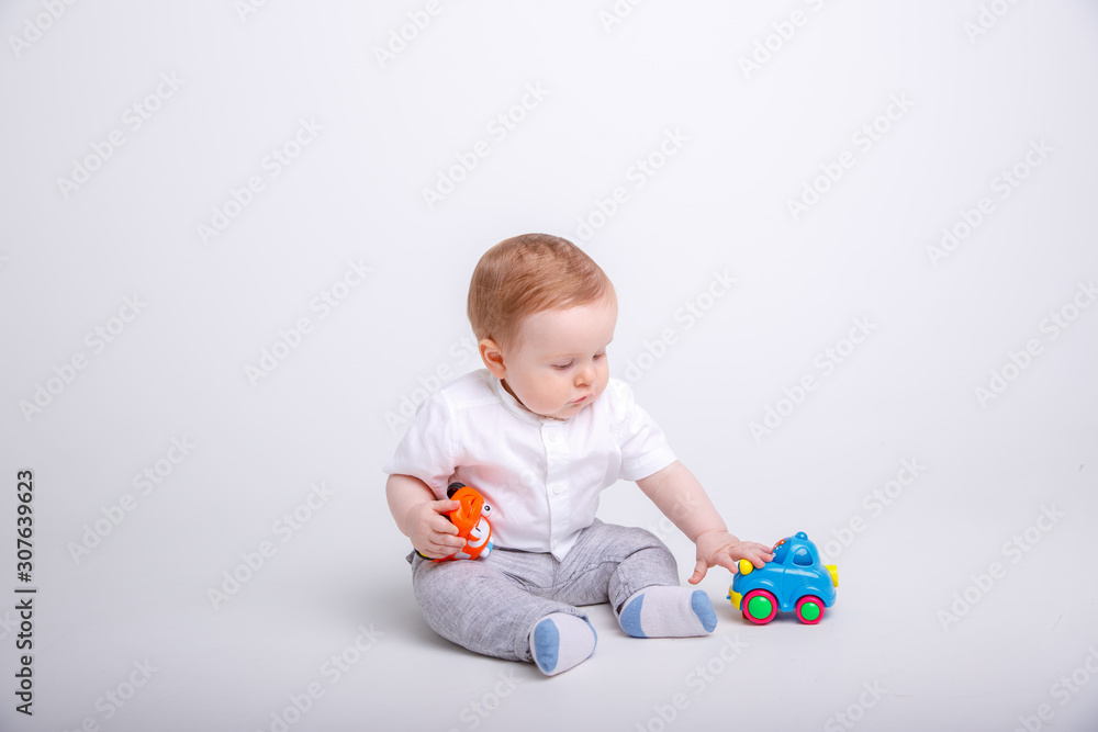 baby boy playing with cars isolated on white background.baby boy sitting on a white background baby boy playing with cars isolated on white background.baby boy sitting on a white background