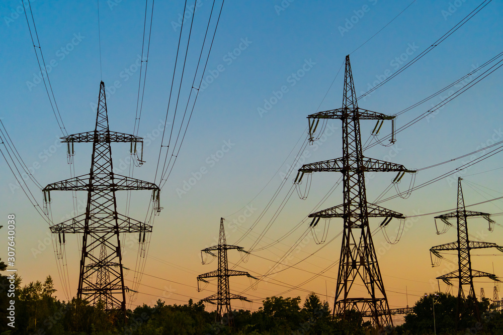 Fototapeta premium High voltage electric tower Silhouette on sunset time, power pylons on sunset time background. Selective focus
