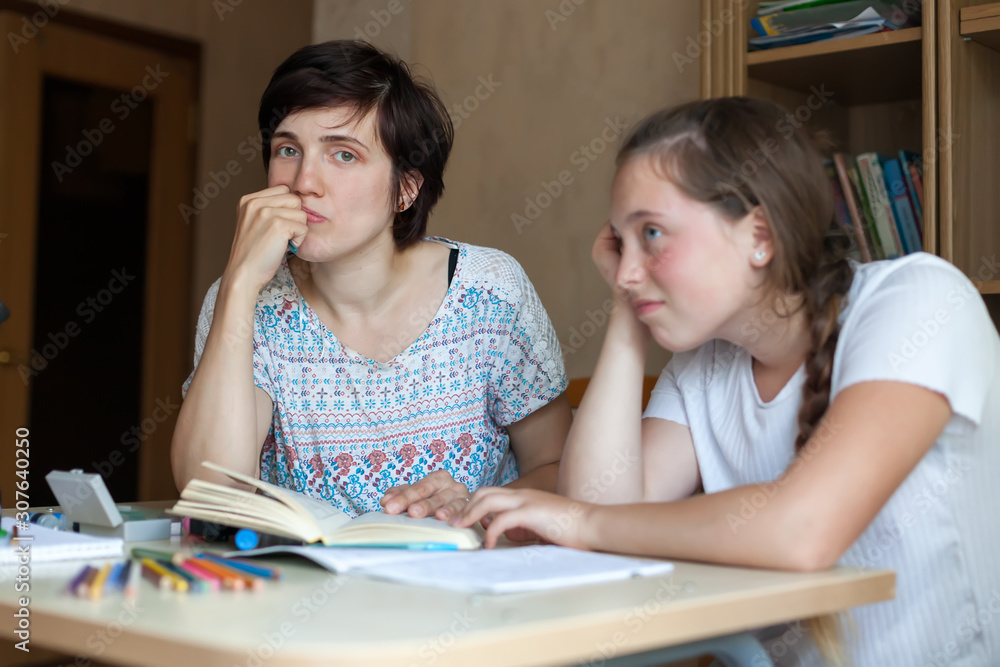 Fototapeta premium Disgruntled mother and teenage child with textbooks and notebooks