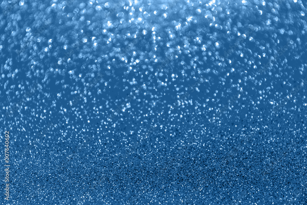 Blurred glitter blue background for holiday and any project. Shallow depth of field. Horizontal