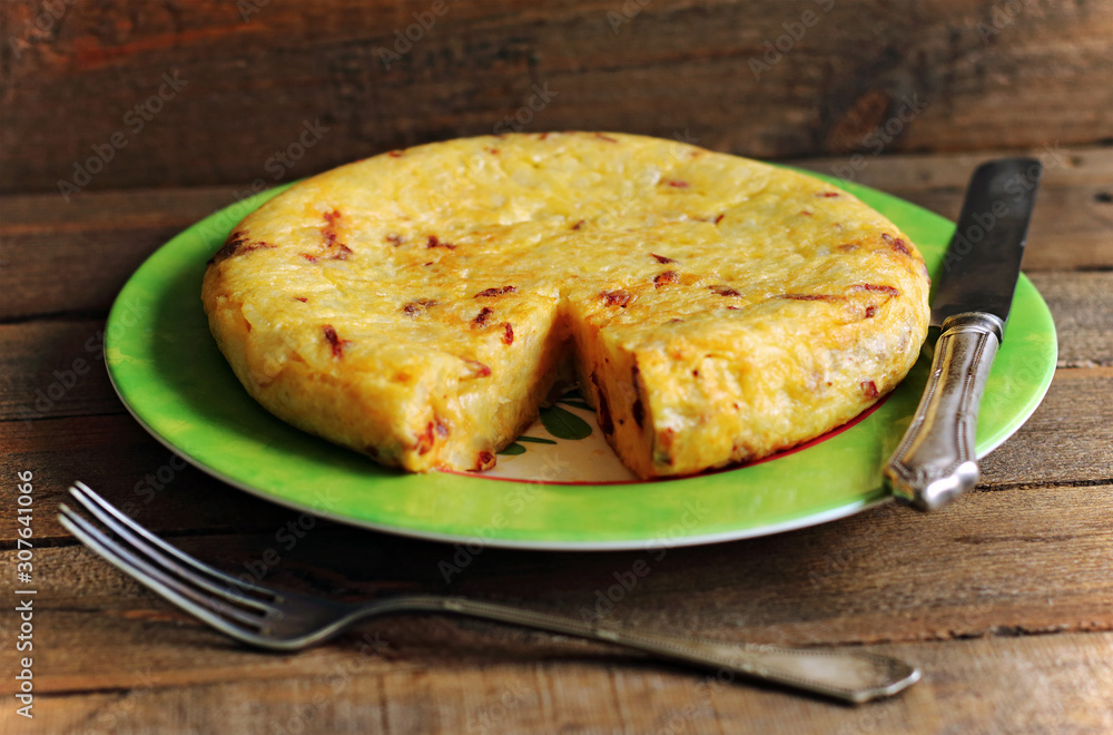 Juicy and tasty Spanish omelette with sausage and silverware Juicy and tasty Spanish omelette with sausage and silverware