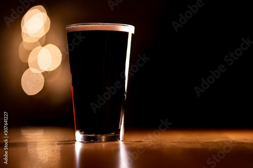 Fényképezés Pint of Dark Stout Beer on a Wooden Table with Copy Space