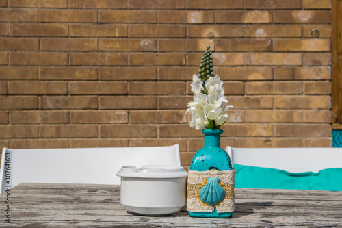 Vase with the flowers on the table in summer cafe. photo