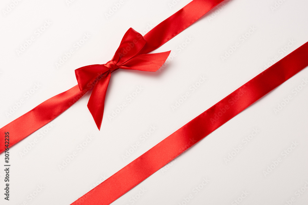 top view of red ribbon with satin bow on white top view of red ribbon with satin bow on white