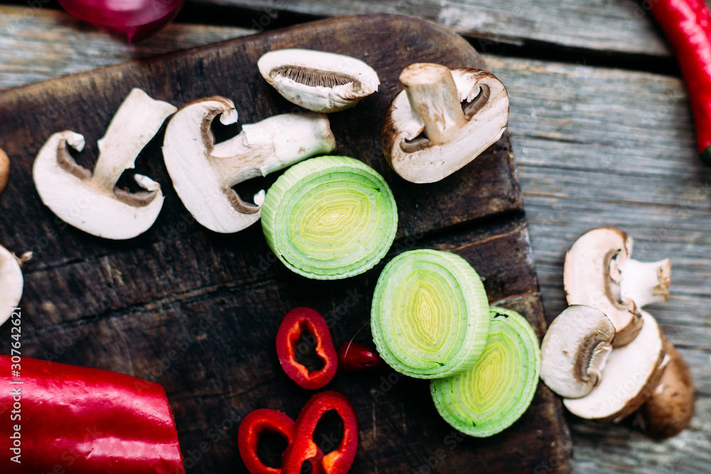 Raw vegetables on a wooden table. Healthy nutrition. Leek, blue onion, champignons, hot pepper, sweet pepper, tomatoes Raw vegetables on a wooden table. Healthy nutrition. Leek, blue onion, champignons, hot pepper, sweet pepper, tomatoes