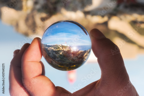 View of the lighthouse through crystal globe at Cape St. Vincent. Continental Europe's most South-western point, Sagres, Algarve, Portugal.