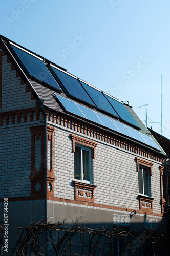  Solar panel system on house roof, sunny blue sky background.Blue solar panels.	