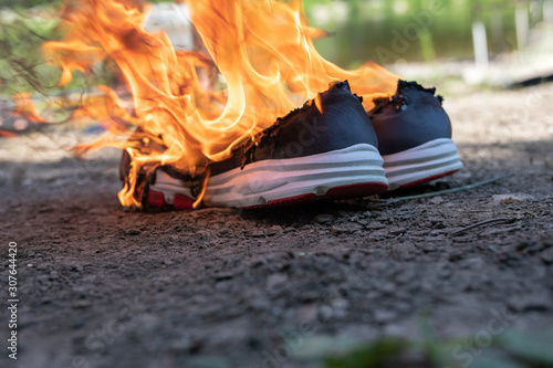 Burning sports sneakers, gym. concept time to buy new pair of shoe. sweat feet, bad smell, spoiled shoes after long use. photo