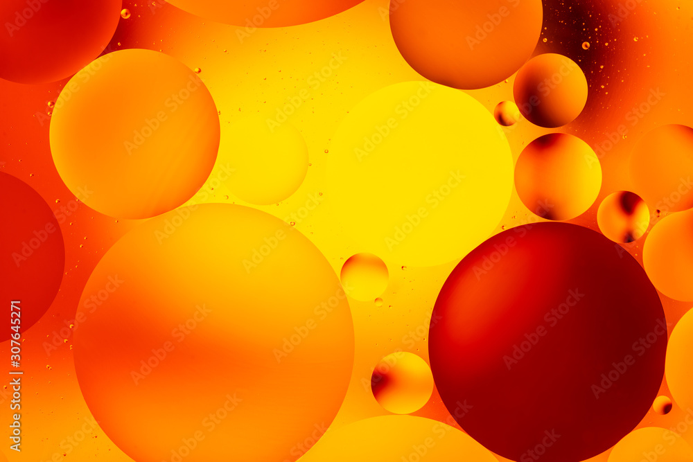 bright oily drops in water with colorful background, close-up 