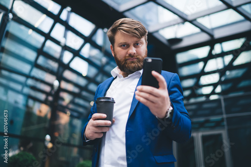 Classy bearded businessman in suit using phone