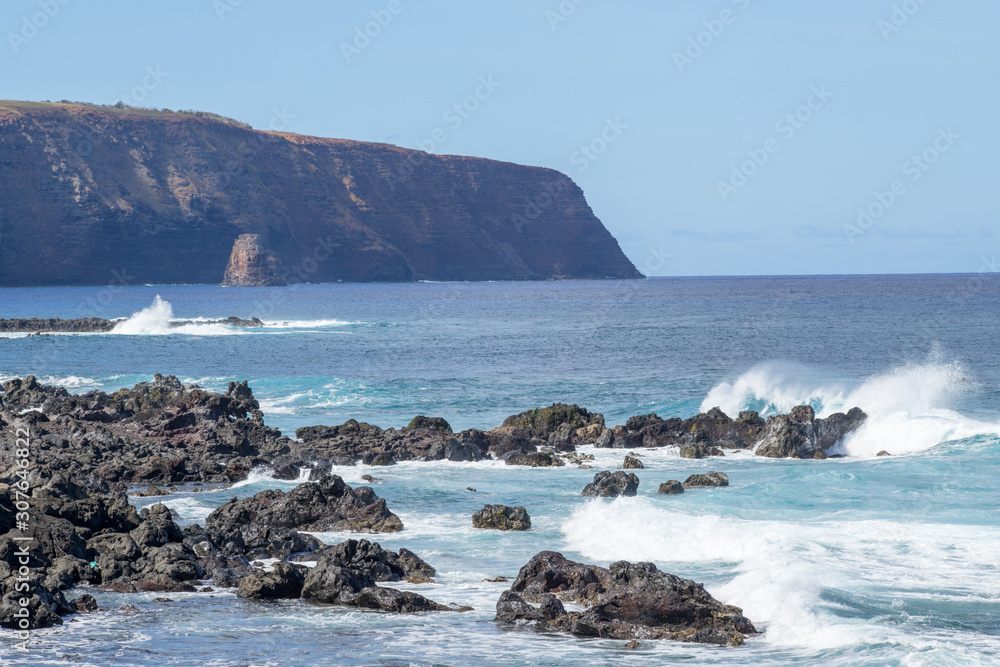 The wild coasts of Easter Island with the cliffs of the Poike volcano on the background. Easter Island, Chile