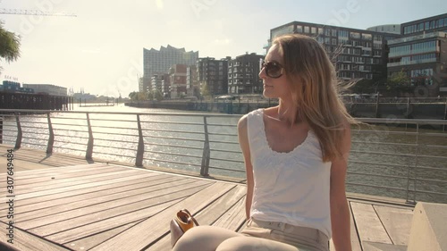 junge Frau sitzt an den Magellan Terrassen, Hamburg Hafencity