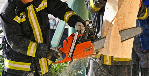 Firefighter works with a chainsaw outdoor