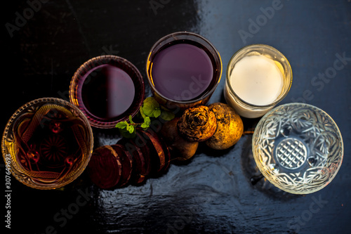 Beetroot face mask on a black glossy surface consisting of some beetroot juice well mixed with milk and honey. Used in a spa for dry skin. Horizontal shot of beetroot face mask on a wooden surface. photo