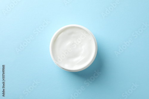 Jar of winter cream for skin on blue background  space for text. Top view