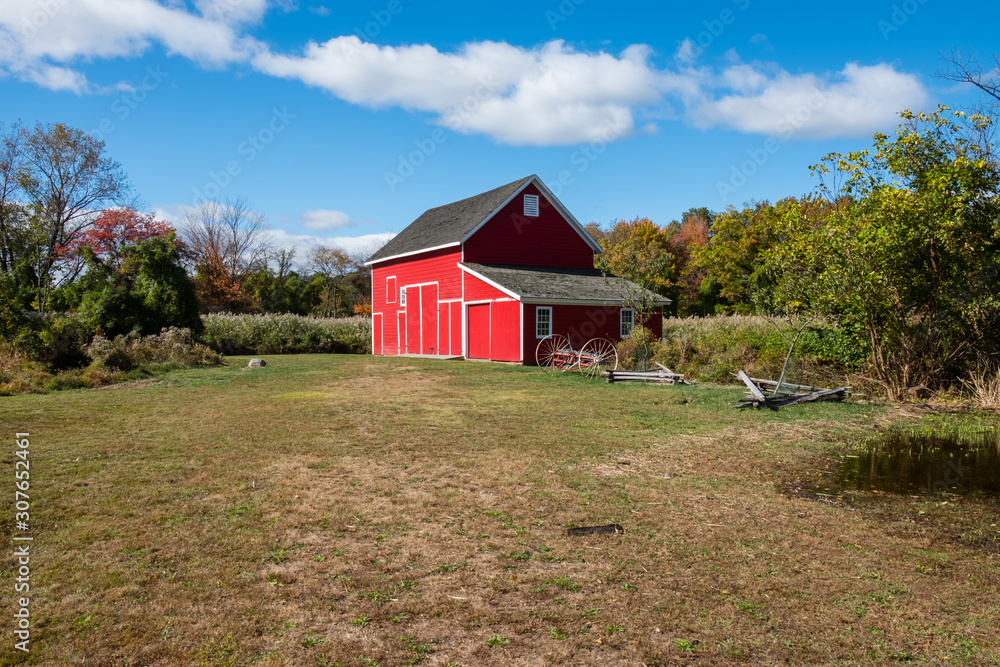 Isolated red barn in wooded area. Red farm barn building exterior. 