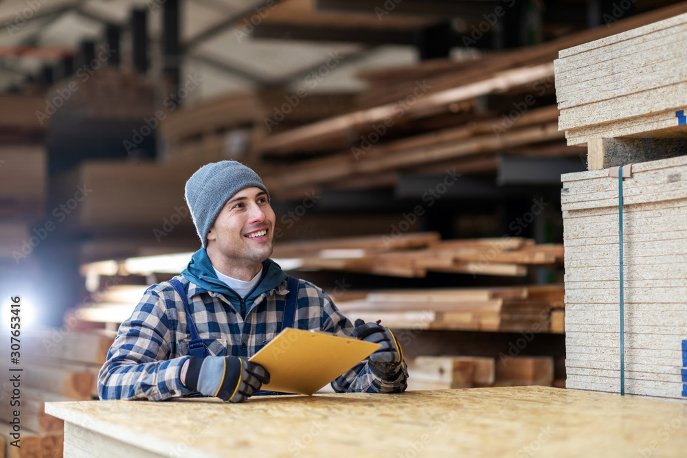 Young male worker in timber warehouse 