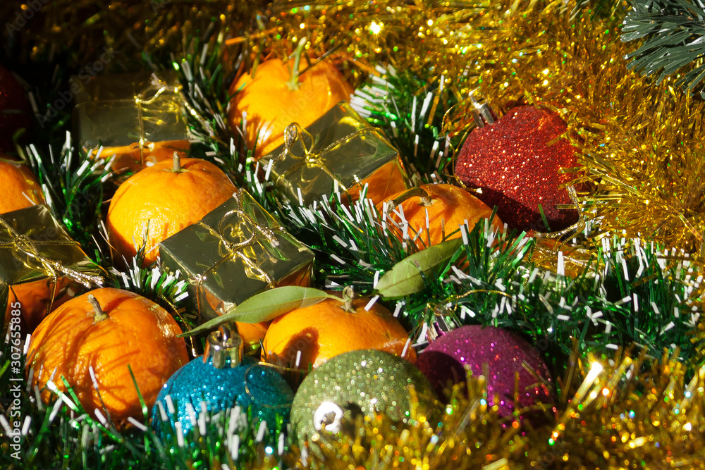 Christmas balls, gift boxes and tangerines on tinsel Christmas balls, gift boxes and tangerines on tinsel