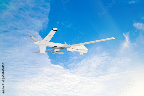 military RC military drone flies against the backdrop of blue peaceful sky with white clouds