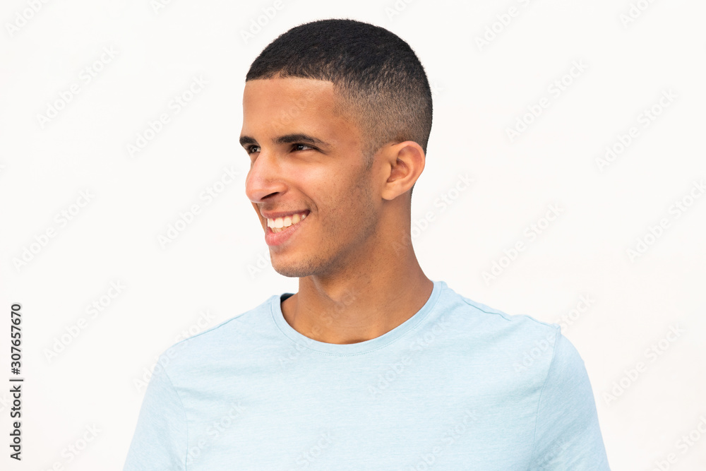 horizontal portrait of happy smiling young North African man looking away by white background horizontal portrait of happy smiling young North African man looking away by white background